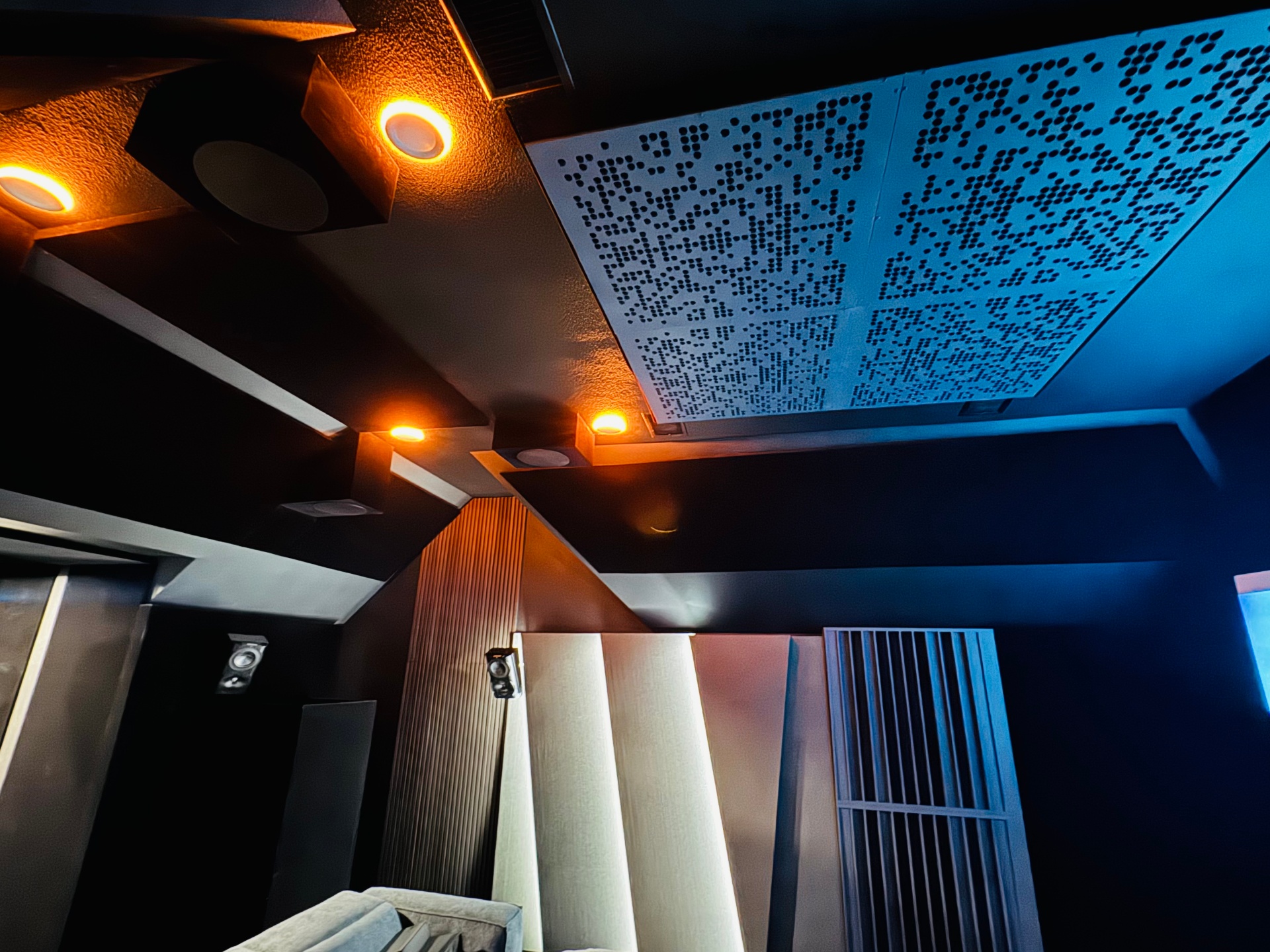 Private home cinema with acoustic ceiling panels and warm architectural lighting
